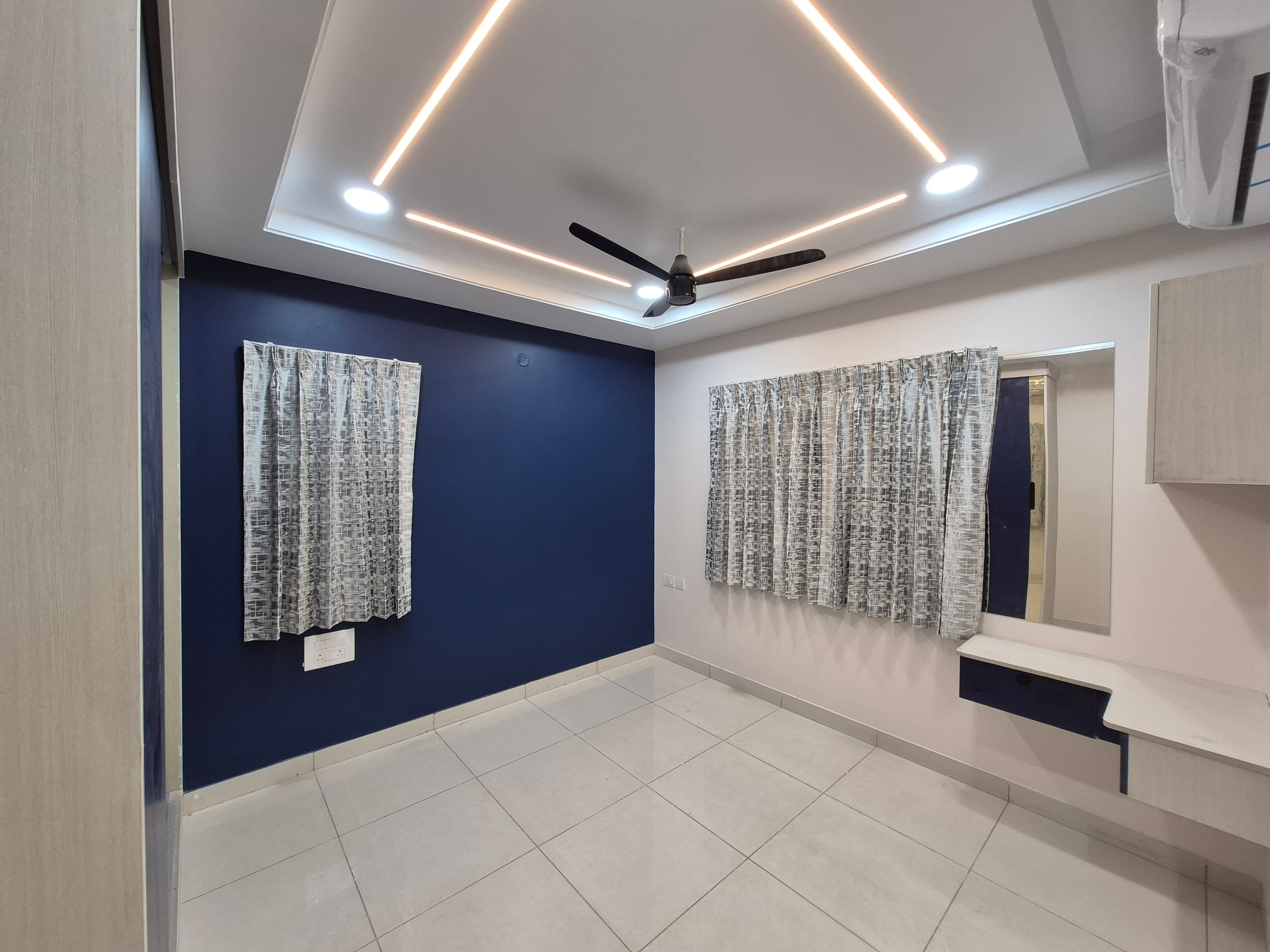 Bedroom with navy accent wall at Amaravati Premium Apartment